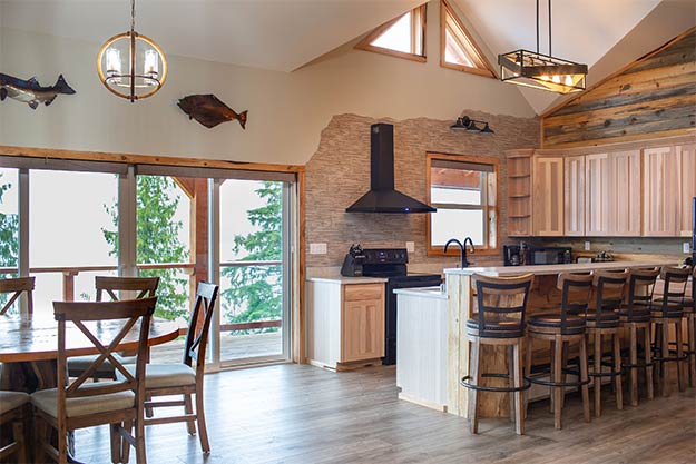 Picture of the Anglers Lodge in Ketchikan, Alaska showing the kitchen and dining area leading out to the oceanview deck